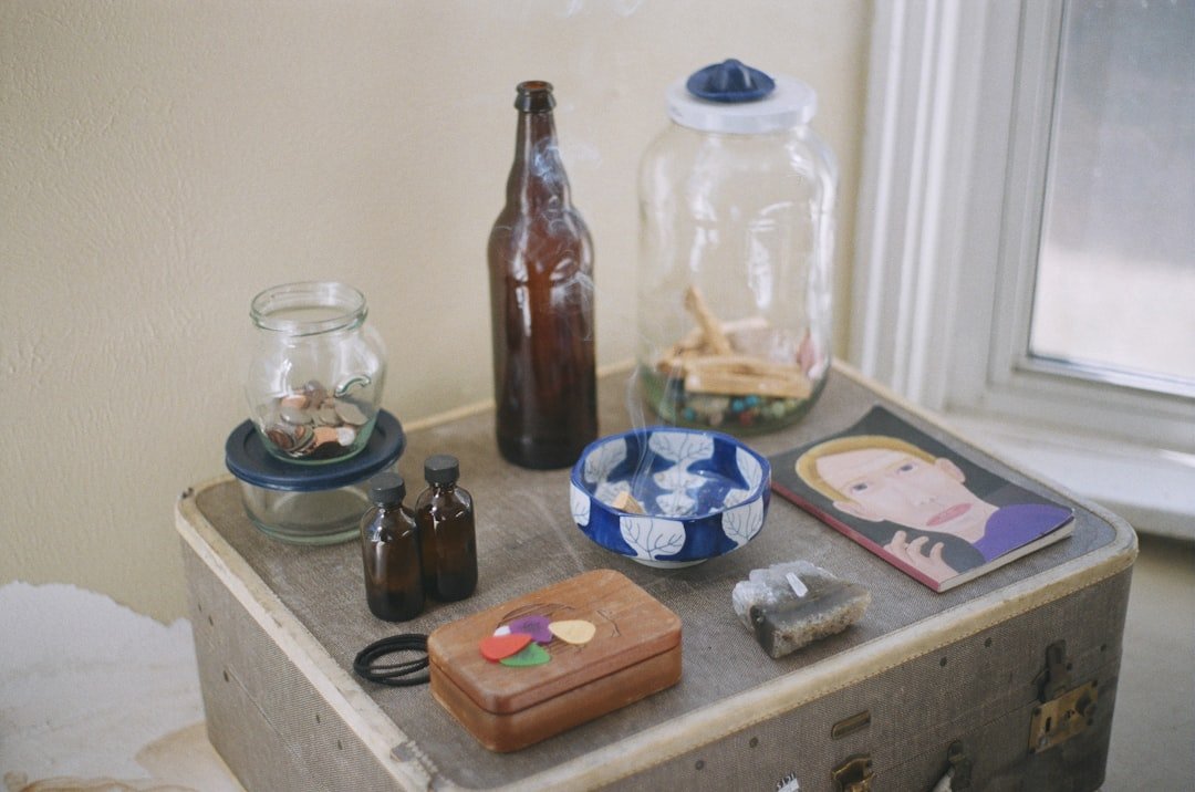 Fermentation equipment laid out on a wooden table including mason jars, glass weights, sea salt, a kitchen scale, and fresh vegetables ready for processing