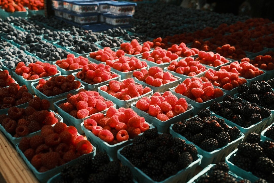 Colorful display of unusual specialty crops at a farmers market including ground cherries, purple carrots, and unusual greens